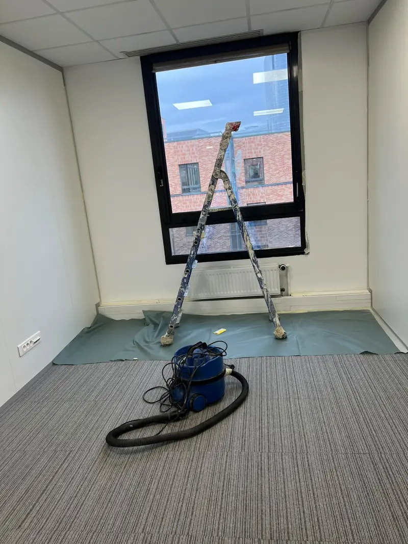 Chantier de peinture dans une pièce avec grande fenêtre