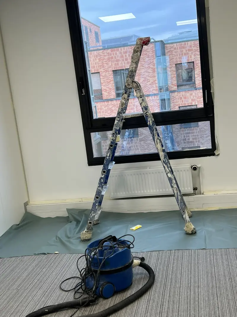 Pièce avec échelle et protection du sol pendant des travaux de peinture