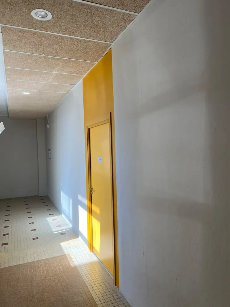 Porte jaune peinte dans un couloir