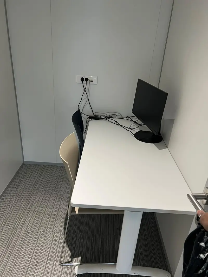 Poste de travail dans une cabine de bureau avec moquette rayée